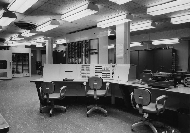 TX-0 (Transistorized Experimental Computer 0), l’un des premiers ordinateurs à transistors, installé au MIT à la fin des années 1950. Au premier plan, la console opérateur et le Flexowriter ; à l’arrière, les baies électroniques.